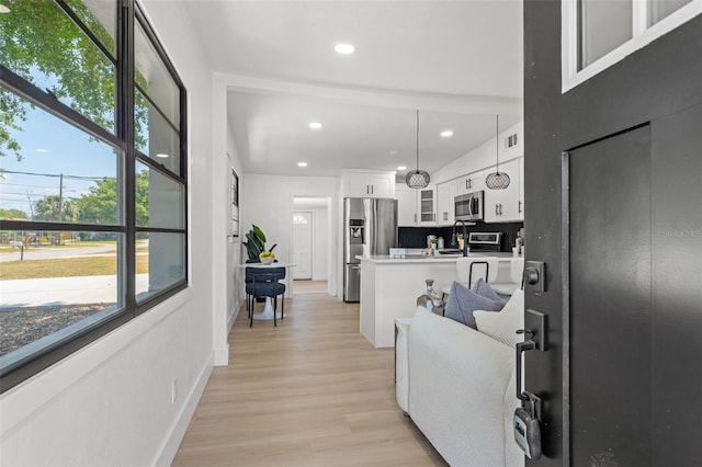 living area with visible vents, a healthy amount of sunlight, light wood-style floors, and recessed lighting