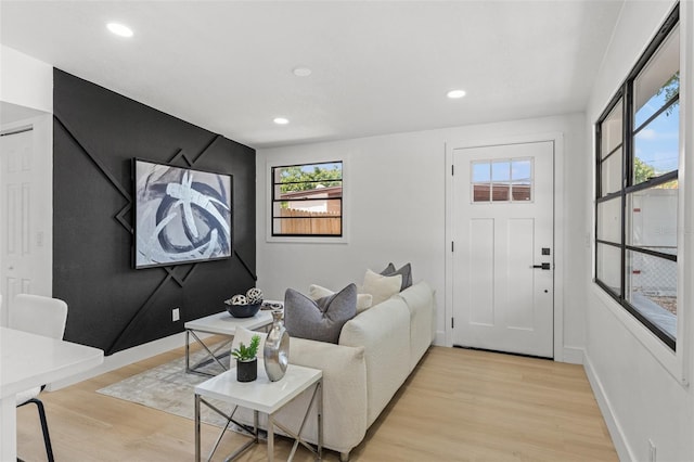living room with baseboards, recessed lighting, and light wood-style flooring
