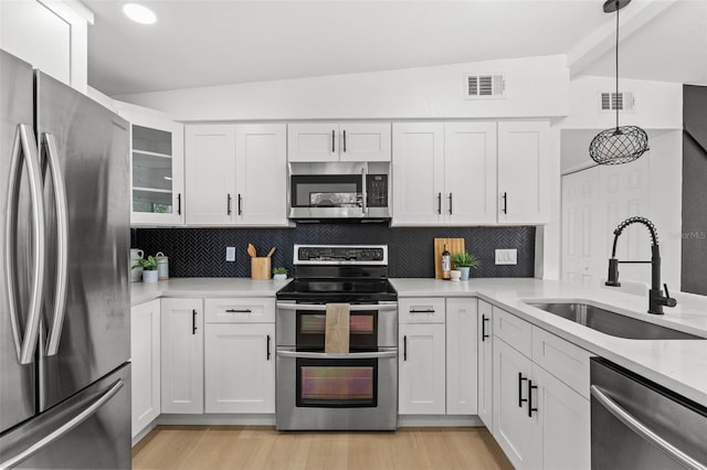 kitchen featuring tasteful backsplash, appliances with stainless steel finishes, light countertops, a sink, and visible vents