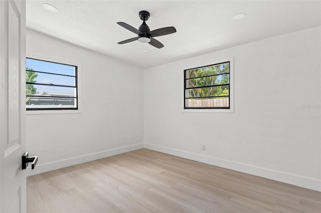 unfurnished room featuring light wood-type flooring, baseboards, and a healthy amount of sunlight