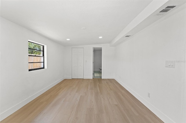unfurnished room featuring baseboards, visible vents, light wood-style floors, and recessed lighting