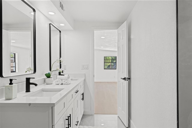 full bathroom with a sink, double vanity, visible vents, baseboards, and recessed lighting