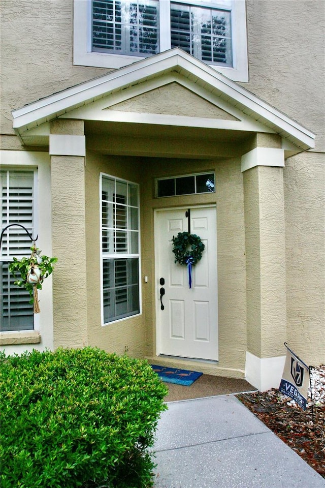 view of exterior entry with stucco siding