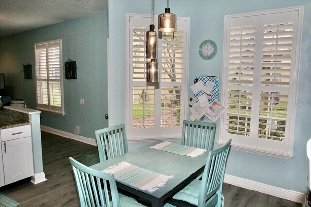 dining room featuring dark wood-style flooring and baseboards