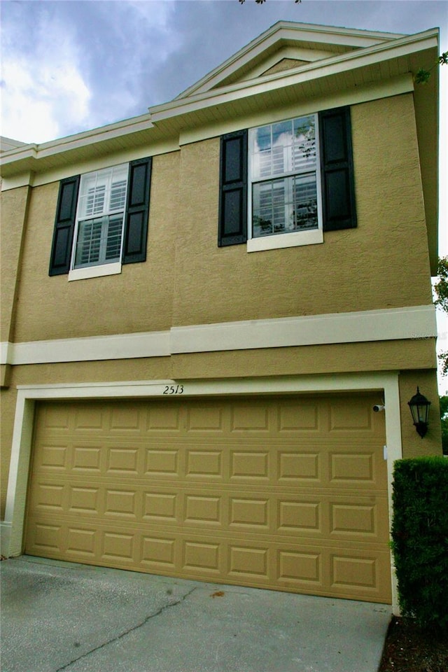 view of front of home featuring a garage, stucco siding, and driveway