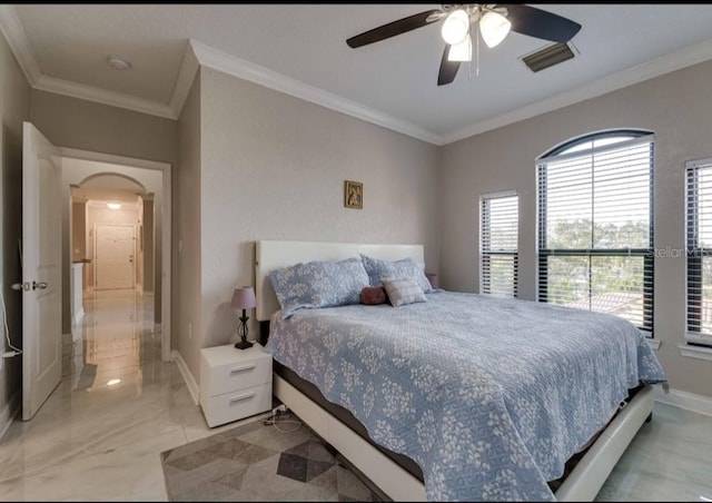 bedroom with crown molding, arched walkways, baseboards, and visible vents