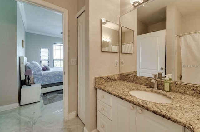 ensuite bathroom with baseboards, ornamental molding, ensuite bath, and vanity