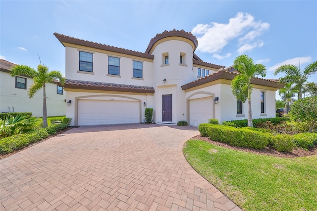 11909 Climbing Fern Ave, Riverview, FL 33579 - mediterranean / spanish-style home with a garage, stucco siding, a tile roof, and decorative driveway