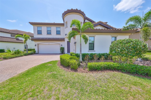 11909 Climbing Fern Ave, Riverview, FL 33579 - mediterranean / spanish-style house with a tiled roof, decorative driveway, an attached garage, stucco siding, and a front lawn