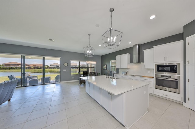 11909 Climbing Fern Ave, Riverview, FL 33579 - kitchen with built in microwave, a notable chandelier, oven, wall chimney exhaust hood, and white cabinets