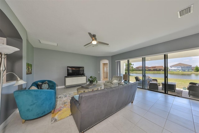 11909 Climbing Fern Ave, Riverview, FL 33579 - living room featuring light tile patterned floors, ceiling fan, visible vents, baseboards, and arched walkways
