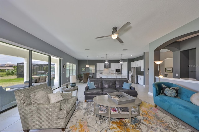 11909 Climbing Fern Ave, Riverview, FL 33579 - living area with light tile patterned floors, arched walkways, and ceiling fan