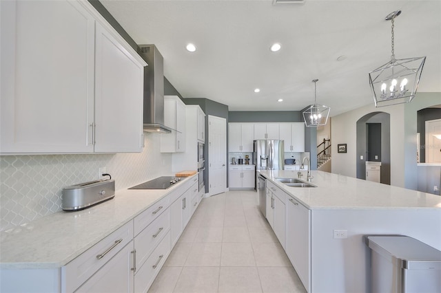 11909 Climbing Fern Ave, Riverview, FL 33579 - kitchen featuring wall chimney range hood, decorative backsplash, a sink, appliances with stainless steel finishes, and arched walkways