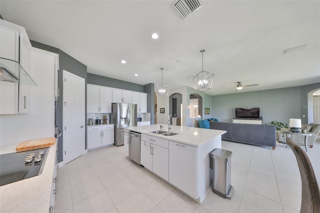 11909 Climbing Fern Ave, Riverview, FL 33579 - kitchen featuring light tile patterned floors, a sink, appliances with stainless steel finishes, light countertops, and arched walkways