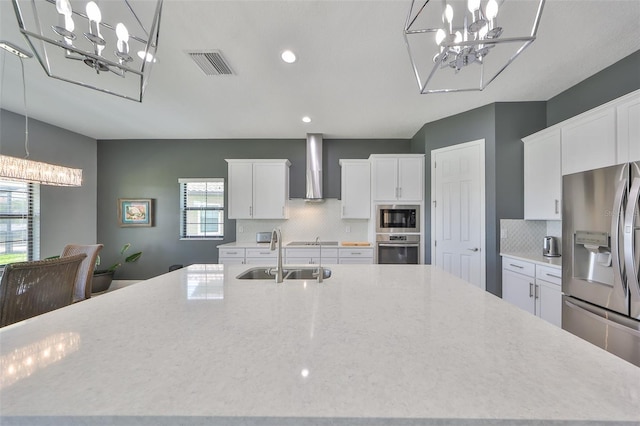 11909 Climbing Fern Ave, Riverview, FL 33579 - kitchen featuring a chandelier, stainless steel appliances, a sink, visible vents, and wall chimney exhaust hood