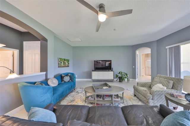 11909 Climbing Fern Ave, Riverview, FL 33579 - living room with a textured ceiling, ceiling fan, baseboards, and arched walkways