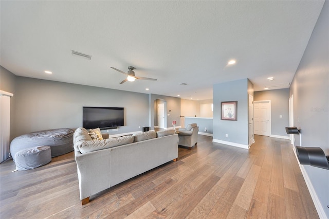 11909 Climbing Fern Ave, Riverview, FL 33579 - living area featuring a ceiling fan, visible vents, baseboards, arched walkways, and wood finished floors