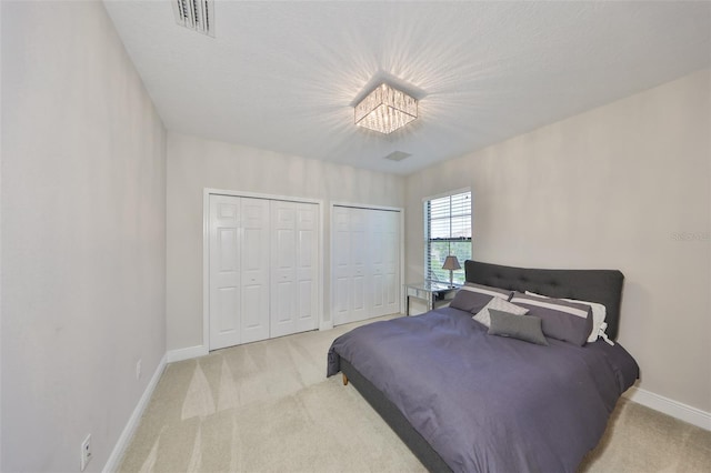 11909 Climbing Fern Ave, Riverview, FL 33579 - bedroom with visible vents, two closets, carpet flooring, and baseboards