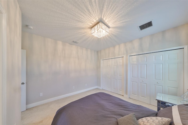 11909 Climbing Fern Ave, Riverview, FL 33579 - bedroom with an inviting chandelier, multiple closets, carpet flooring, baseboards, and visible vents