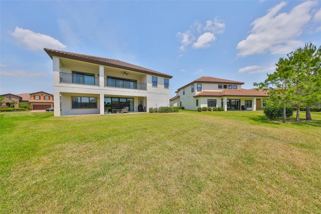 11909 Climbing Fern Ave, Riverview, FL 33579 - back of property with a lawn, a balcony, stucco siding, and a tile roof