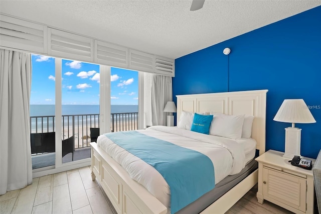 9980 Gulf Blvd Unit 603, Treasure Island, FL 33706 - bedroom with a water view, access to outside, a textured ceiling, and ceiling fan