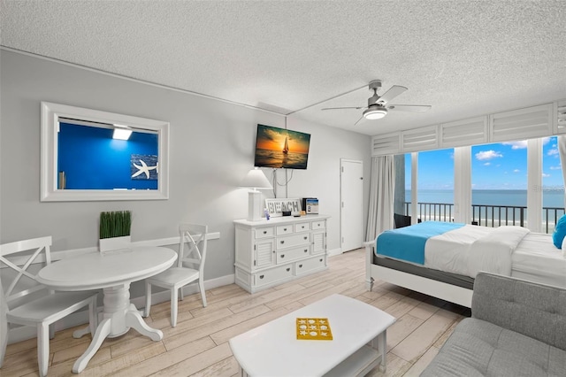 9980 Gulf Blvd Unit 603, Treasure Island, FL 33706 - bedroom featuring access to outside, light wood-style floors, a textured ceiling, and a ceiling fan