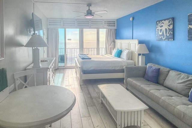 9980 Gulf Blvd Unit 603, Treasure Island, FL 33706 - bedroom with access to outside, light wood-type flooring, a textured ceiling, and ceiling fan