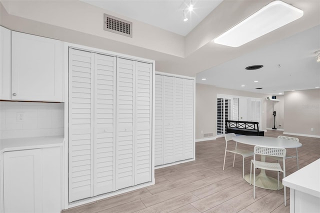 307 Orangewood Ln, Largo, FL 33770 - kitchen featuring visible vents, light countertops, white cabinets, open floor plan, and light wood-style floors