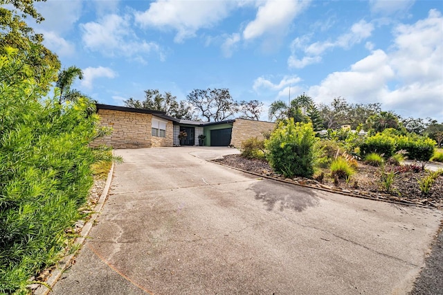 307 Orangewood Ln, Largo, FL 33770 - view of front of home featuring concrete driveway, an attached garage, and stone siding