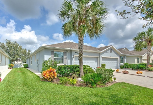 view of front of home featuring an attached garage, driveway, stucco siding, and a front yard