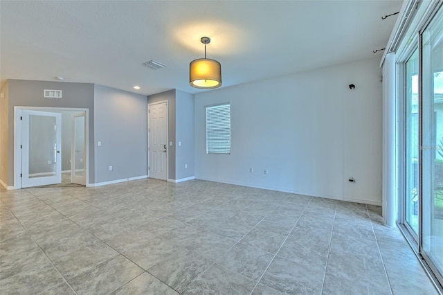 spare room featuring baseboards, visible vents, and plenty of natural light