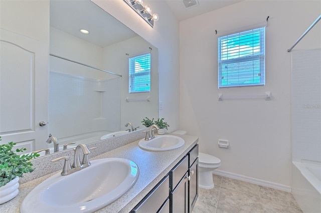 bathroom with baseboards, a sink, bathtub / shower combination, and toilet