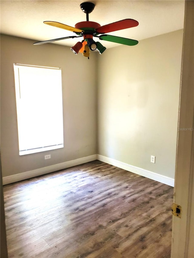 empty room featuring ceiling fan, wood finished floors, and baseboards