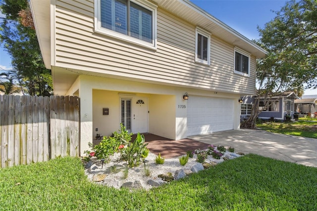 1735 Maryland Ave NE, Saint Petersburg, FL 33703 - view of front facade with fence, a garage, and stucco siding