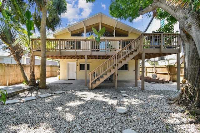 1735 Maryland Ave NE, Saint Petersburg, FL 33703 - rear view of property featuring a wooden deck, fence, stairway, and a patio area