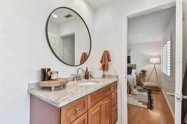 1735 Maryland Ave NE, Saint Petersburg, FL 33703 - ensuite bathroom with wood finished floors, vanity, and baseboards