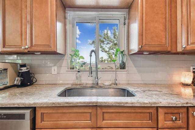 1735 Maryland Ave NE, Saint Petersburg, FL 33703 - kitchen with a sink, dishwasher, backsplash, brown cabinets, and light stone counters