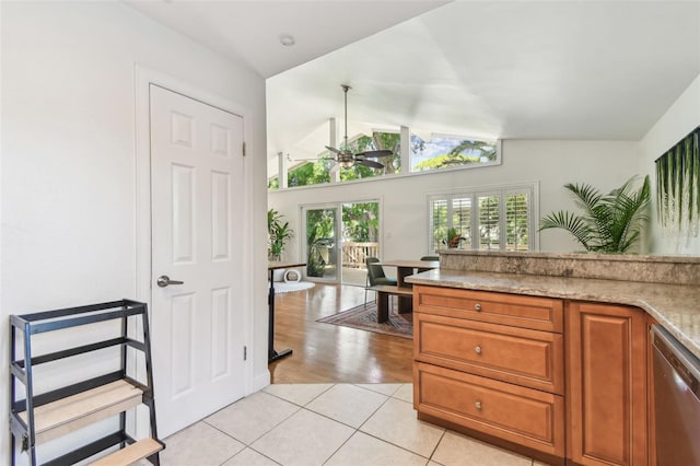 1735 Maryland Ave NE, Saint Petersburg, FL 33703 - kitchen with stainless steel dishwasher, vaulted ceiling, light tile patterned flooring, and brown cabinetry