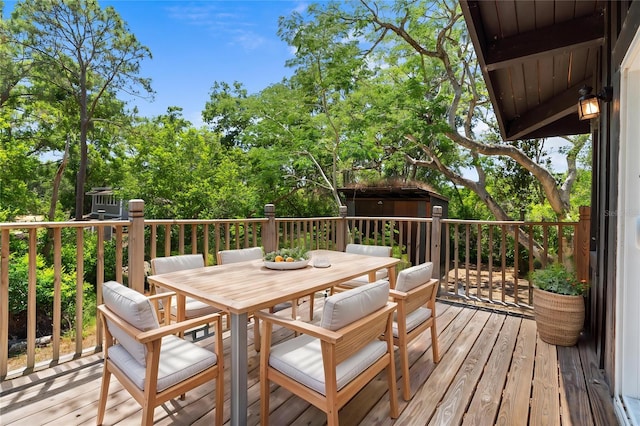 deck with a storage unit, an outbuilding, and outdoor dining area
