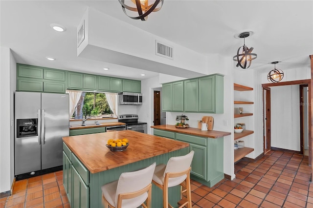 kitchen featuring open shelves, a sink, green cabinets, wood counters, and stainless steel appliances
