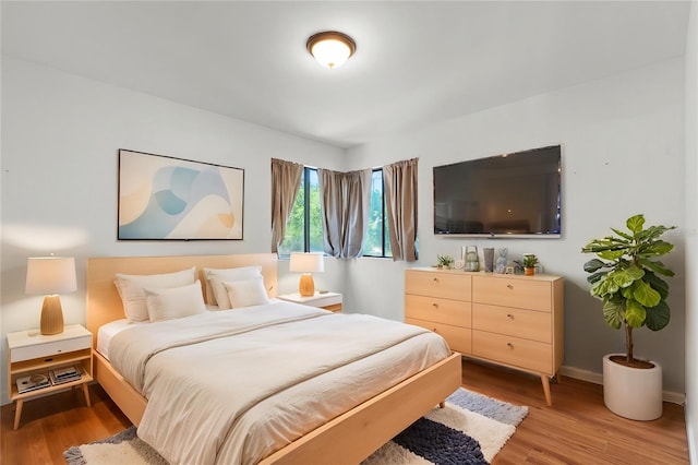bedroom with baseboards and wood finished floors
