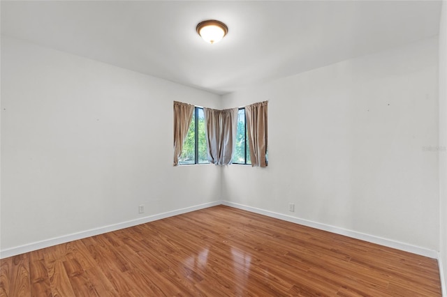 unfurnished room featuring baseboards and wood finished floors