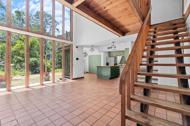 stairway with beam ceiling, wood ceiling, tile patterned floors, and high vaulted ceiling
