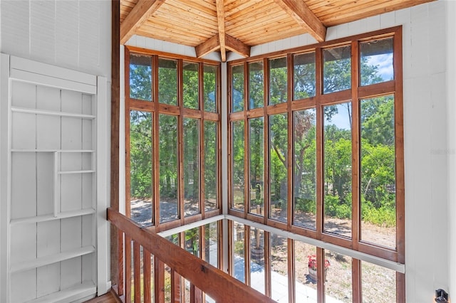 unfurnished sunroom featuring beam ceiling
