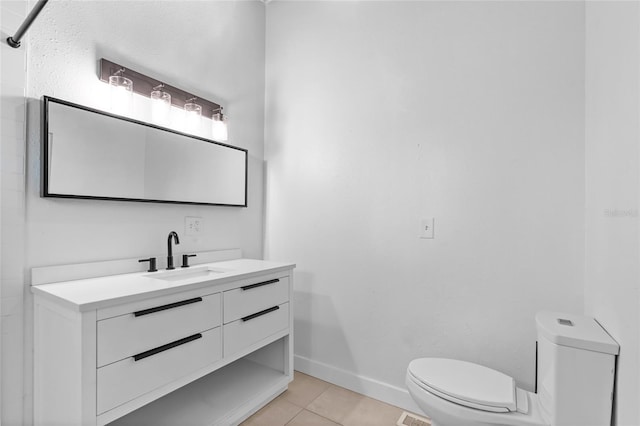 bathroom featuring toilet, tile patterned floors, baseboards, and vanity