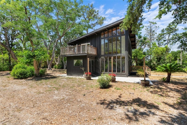 back of house featuring a sunroom and a deck