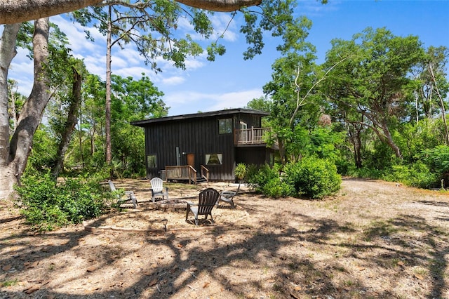 view of yard featuring a fire pit and a balcony