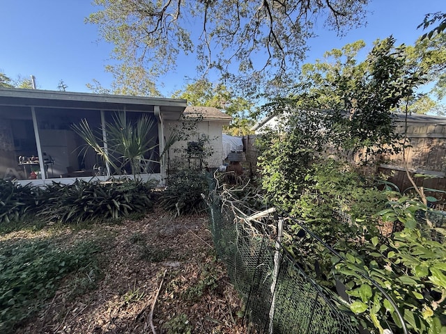 view of yard with fence and a sunroom