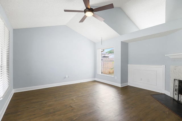 1227 Tuxford Dr, Brandon, FL 33511 - unfurnished living room featuring dark wood-style flooring, a ceiling fan, vaulted ceiling, and a fireplace with flush hearth