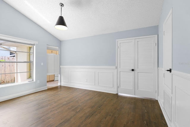 1227 Tuxford Dr, Brandon, FL 33511 - unfurnished bedroom with a textured ceiling, a wainscoted wall, wood finished floors, vaulted ceiling, and a closet